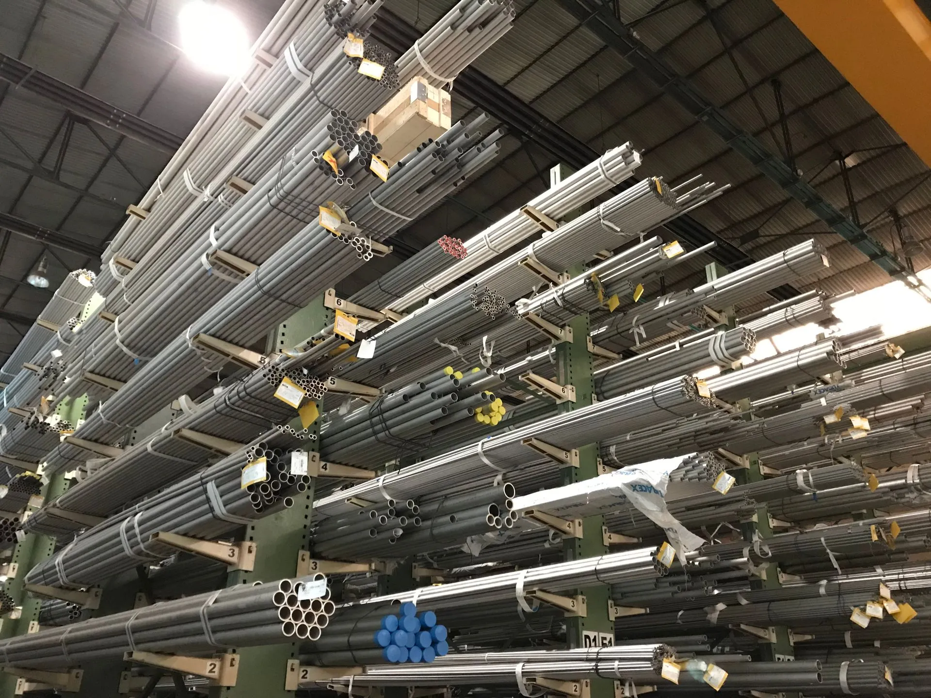 Racks cantilever llenos de paquetes de tubería de acero etiquetados en almacén